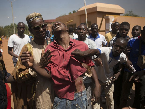 Manifestante baleado é amparado em Ouagadougou, capital de Burkina Faso, durante protestos na quinta-feira (30) (Foto: Reuters/Joe Penney)