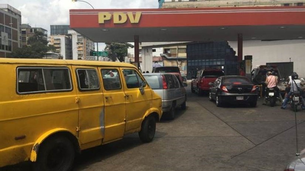 Muitos motoristas não pagam pelo combustível neste posto de gasolina em Caracas — Foto: BBC