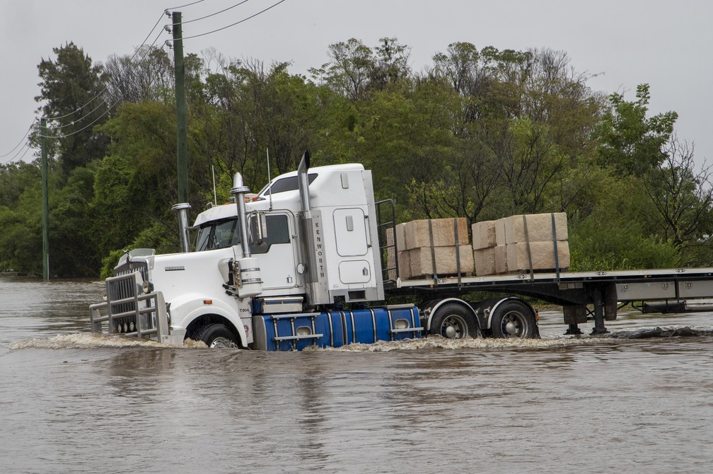 Um caminhão passa por uma estrada inundada em Old Pitt Town, a noroeste de Sydney, Austrália. — Foto: ASSOCIATED PRESS