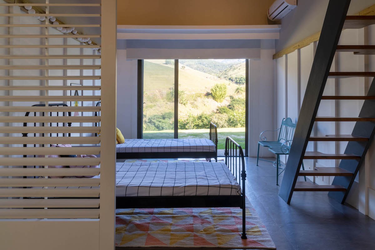QUARTO | As camas de ferro e o banco azul são da Loeil e trazem uma atmosfera despojada para o quarto das crianças (Foto: Divulgação / André Nazareth)