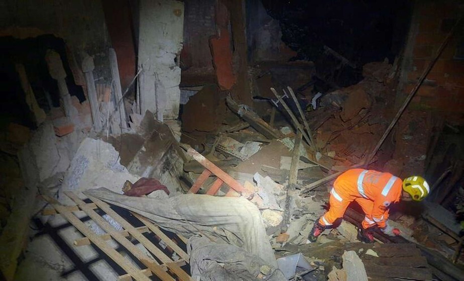 Bombeiros trabalham em escombros de casa que desabou em Barbacena