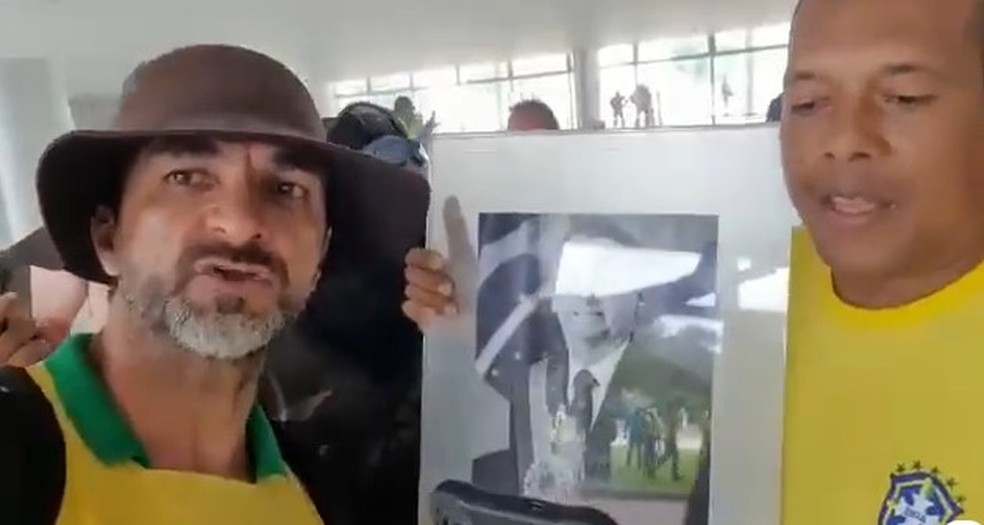 De barba, à esquerda, Alcimar Francisco da Silva fez vídeo com quadro do ex-presidente Jair Bolsonaro — Foto: Redes Sociais