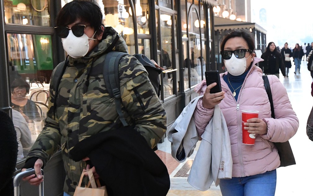 Turistas usam máscaras durante passeio na galeria Vittorio Emanuele II, em Milão, na Itália, na segunda-feira (24) — Foto: Miguel Medina/AFP