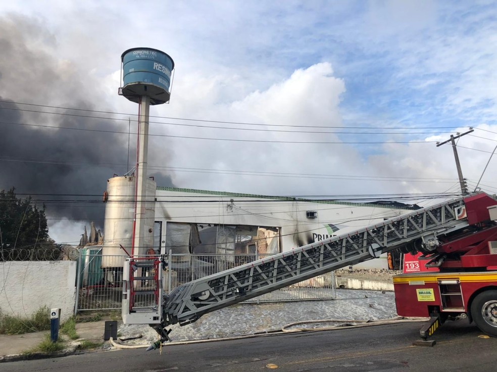 Uma escada foi usada para o acesso dos bombeiros a parte de cima da fábrica durante incêndio em Maceió — Foto: Douglas França/TV Gazeta