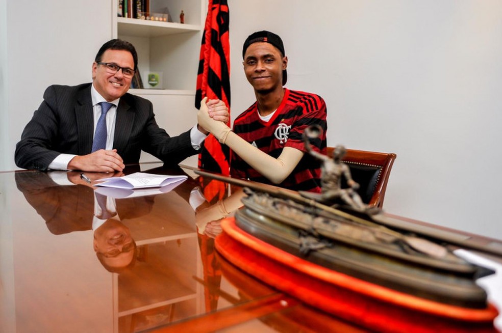 Jhonata com o vice do Flamengo, Rodrigo Dunshee, na assinatura de acordo indenizatório — Foto: Marcelo Cortes/Flamengo