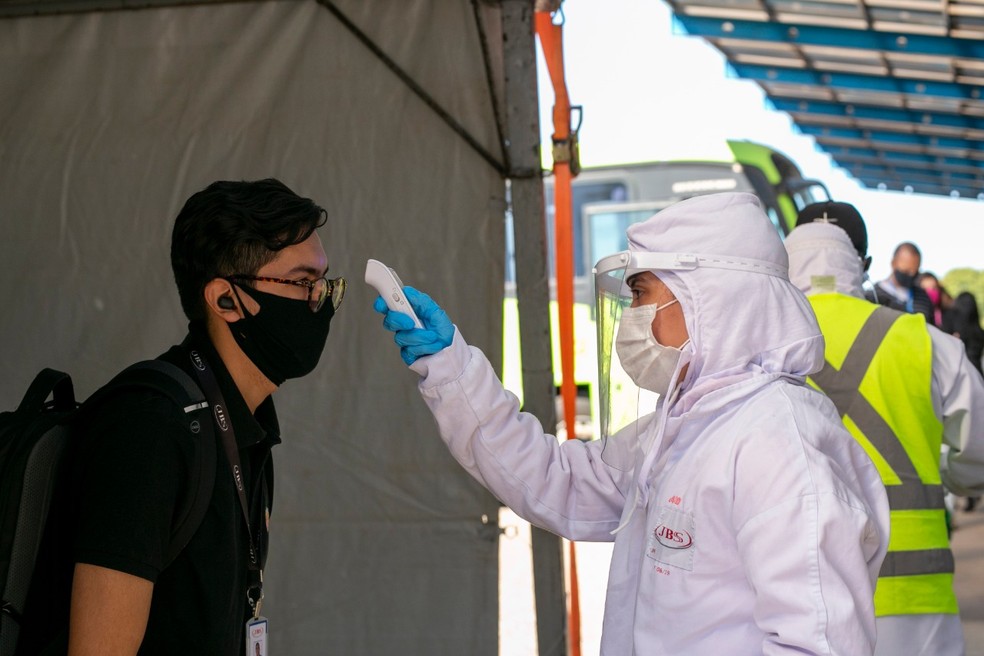Funcionários têm temperatura aferida antes de entrar no transporte, em uma das modificações implementadas pela empresa — Foto: Divulgação/JBS