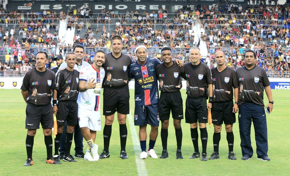 Carlinhos Maia e Ronaldinho posam para foto com o árbitro Chicão — Foto: Ailton Cruz/Gazeta de Alagoas