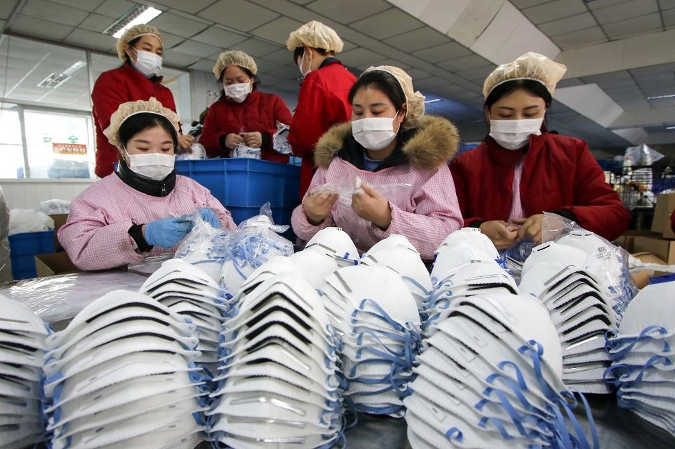 22 de janeiro de 2020  - Trabalhadores produzem máscaras em uma fábrica em Handan, na província de Hebei, no norte da China. País proibiu trens e aviões de deixar Wuhan, epicentro do surto de coronavírus. — Foto: STR / AFP