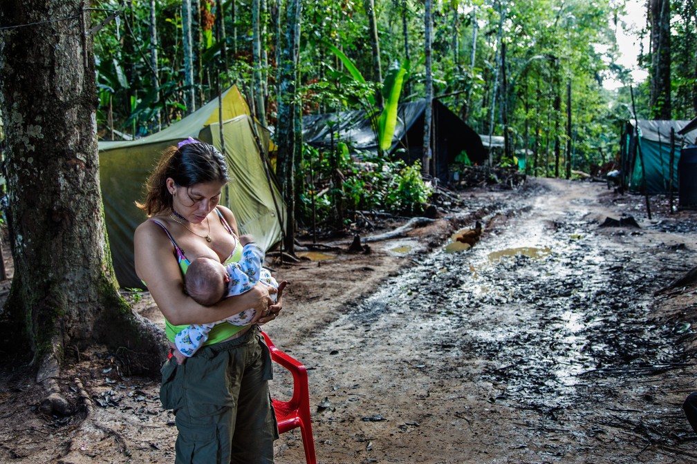 Guerrilheira das Forças Armadas Revolucionárias da Colômbia (Farc) amamenta bebê em ocupação — Foto: Catalina Martin-Chico/Divulgação