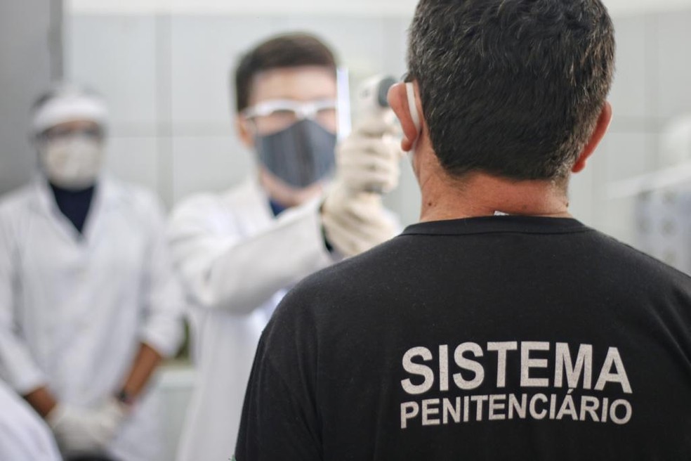 Profissional da saúde mede temperatura de preso com termômetro digital durante pandemia da Covid-19 no Piauí — Foto: Thanandro Fabrício/Sejus