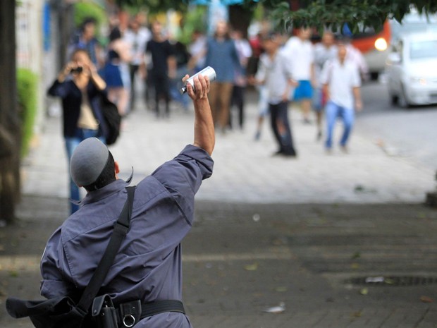 Policial atira lata de gás lacrimogêneo contra estudantes da Escola Estadual Fidelino Figueiredo que bloquearam o cruzamento das avenidas São João e Angélica, na Zona Oeste de São Paulo (Foto: Werther Santana/Estadão Conteúdo)