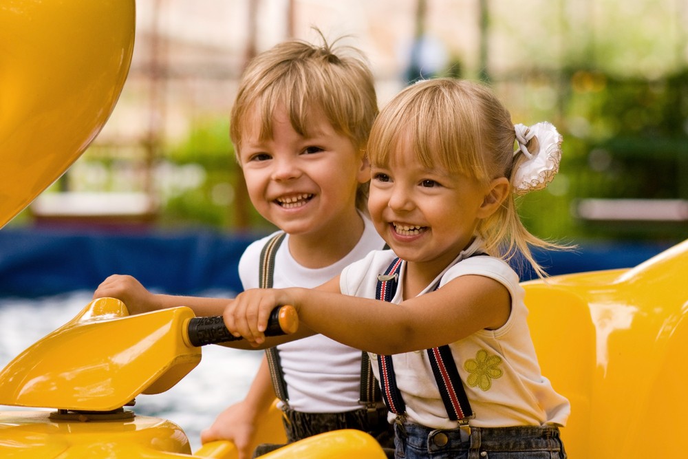 Irmãos brincando em parque de diversão (Foto: Shutterstock)