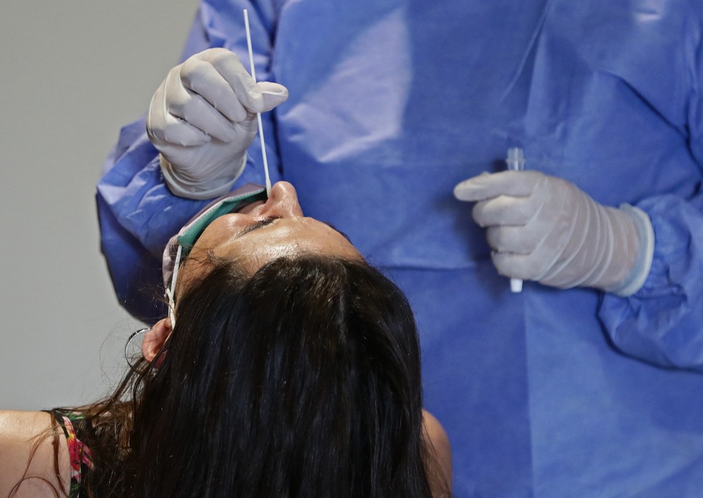 Profissional de saúde coleta amostra nasal de mulher para teste de Covid-19 em um centro de testagem gratuita em Buenos Aires, na Argentina, no dia 10 de janeiro. — Foto: Alejandro Pagni / AFP