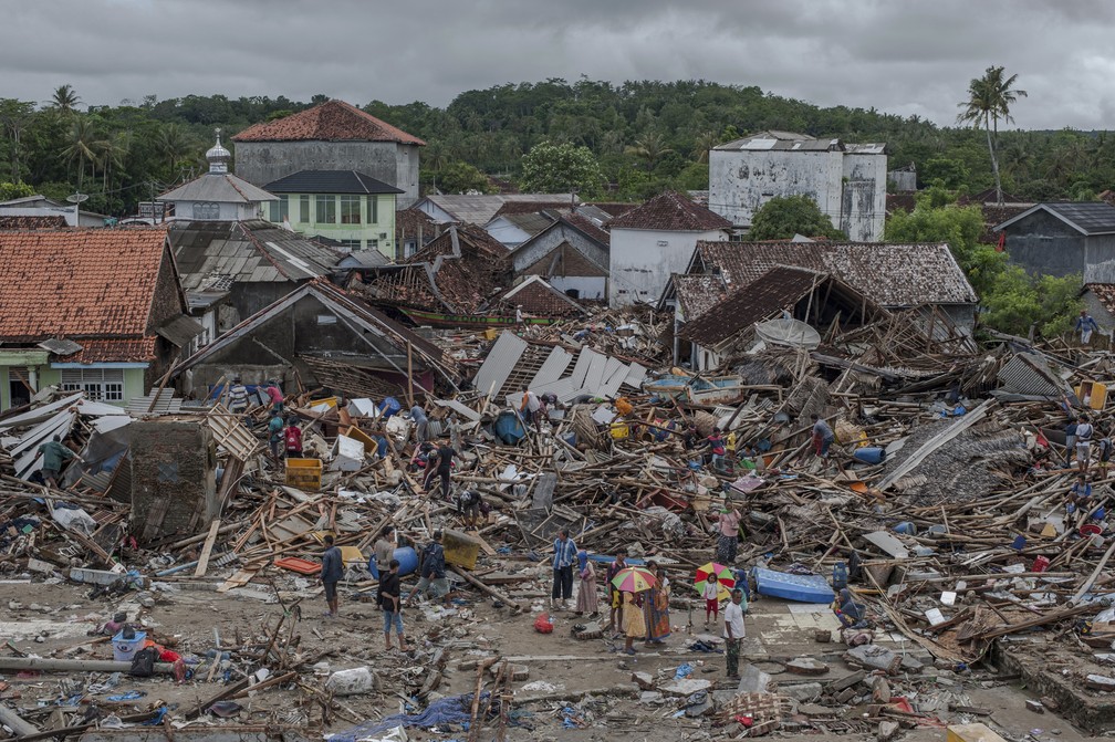 Pessoas inspecionam nesta segunda-feira (24) Ã¡rea destruÃ­da pelo tsunami em Sumur, na IndonÃ©sia â Foto: Fauzy Chaniago/AP Photo