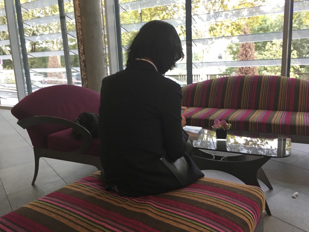 Grace Meng, mulher do presidente da Interpol, Meng Hongwei, consulta seu celular em um hotel de Lyon, na França; ela não quis mostrar seu rosto, pois teme por sua segurança — Foto: John Leicester/AP Photo