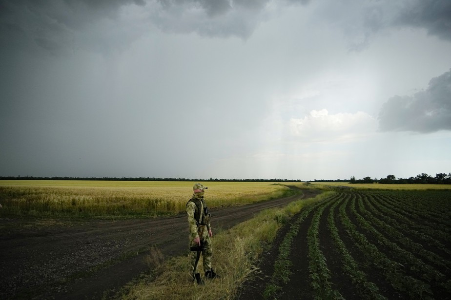 Soldado russo guarda uma área próxima a um campo de trigo na Ucrânia