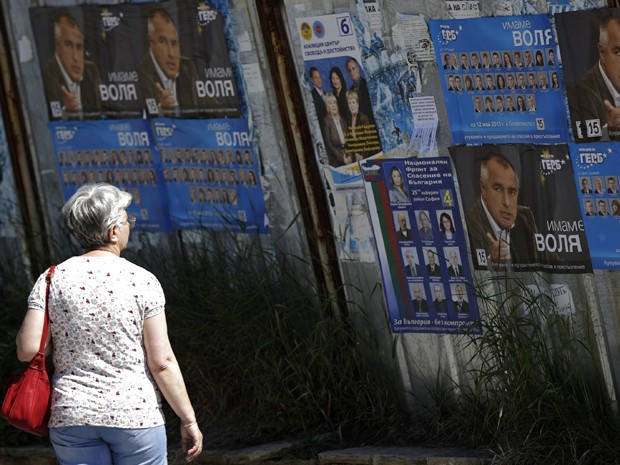 Mulher olha para cartazes eleitorais de Boiko Borisov, líder do partido GERB de centro-direita  na Bulgária, em um subúrbio de Sofia no sábado (11) (Foto: REUTERS / Stoyan Nenov )
