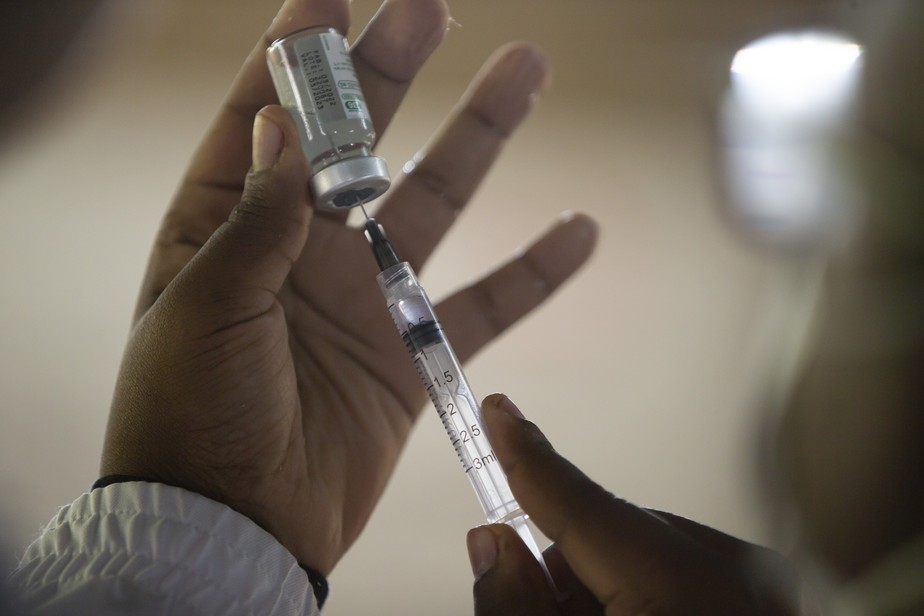 Profissional de saúde com seringa retira dose da vacina contra a Covid-19