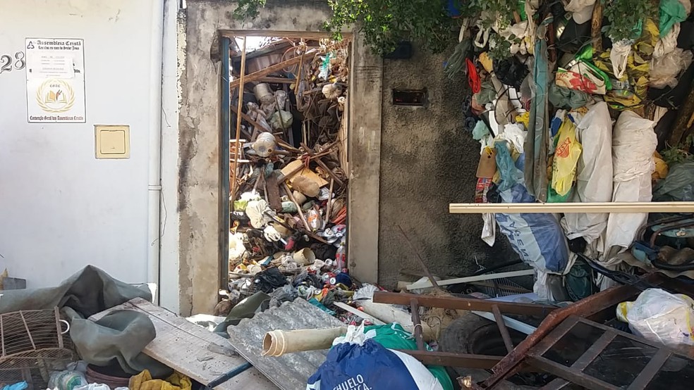 Acessos ao imóvel foram tomados pelo lixo e dificultaram trabalhos de agentes da Defesa Civil e bombeiros — Foto: Claudia Assencio/ g1