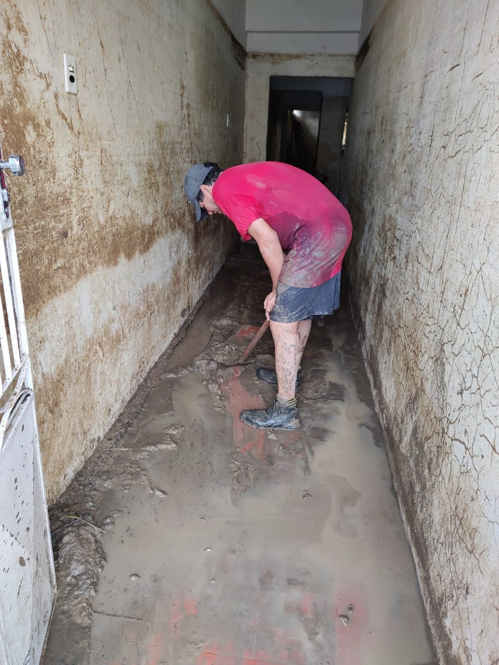 Morador limpa a lama da inundação em Rio Largo, Alagoas — Foto: Rodinei Paulino/Arquivo Pessoal