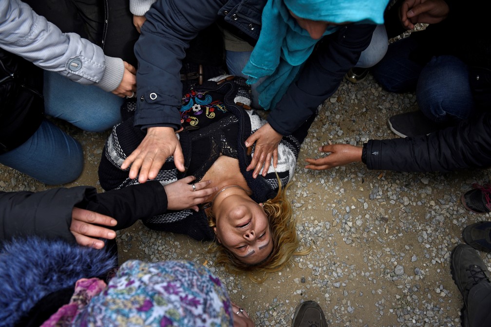 Mulher desmaia enquanto imigrantes entram em confronto com a polícia grega na fronteira norte do país nesta sexta (5), em uma tentativa de chegar ao norte da Europa. — Foto: Alexandros Avramidis/Reuters