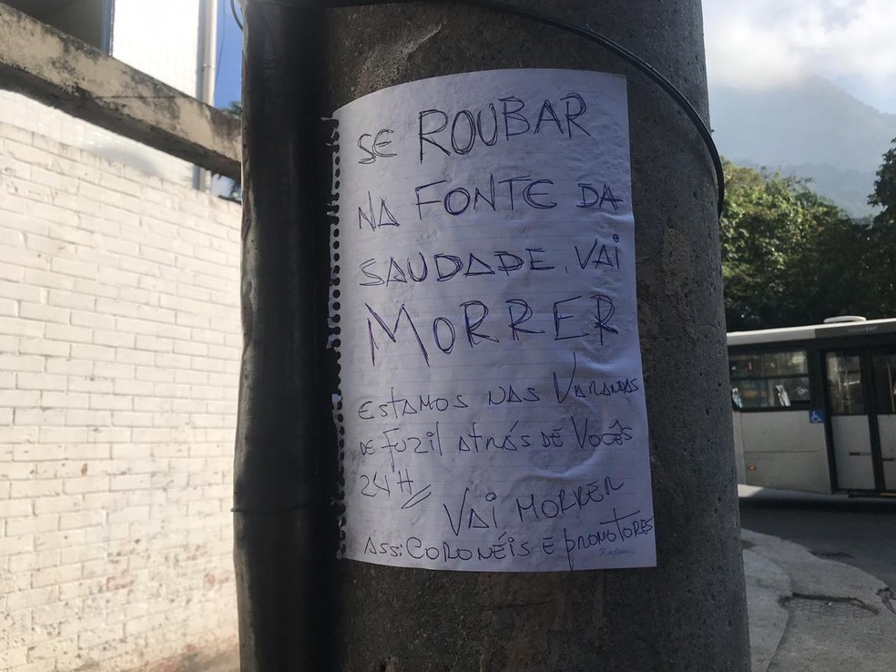 Papel foi colado em poste perto do local do crime — Foto: Lívia Torres/G1