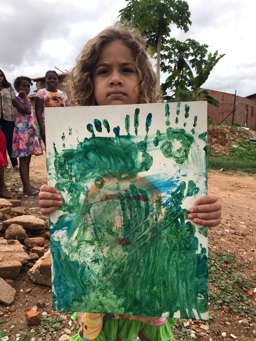 Luna, 4 anos, mostra a "obra de arte" que o irmão Isaac quer vender. — Foto: Neyara Pinheiro/TV Clube