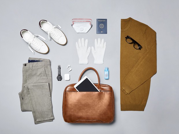 Flat lay of smart casual with handbag and shoes. Men's clothing is arranged on gray background. Menswear with personal accessories against Covid-19. (Foto: Getty Images)