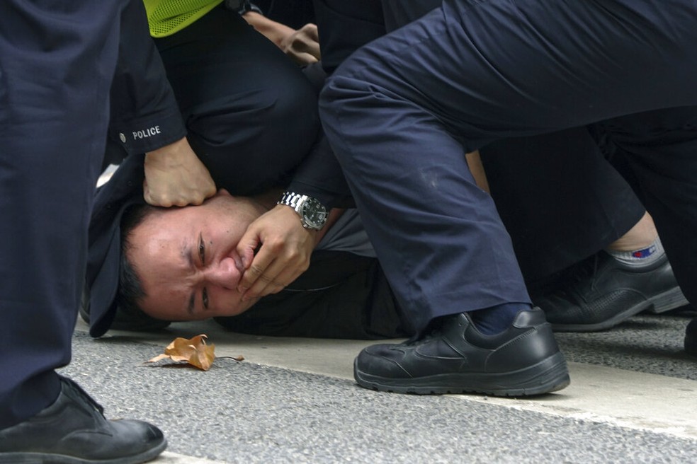 Manifestante é imobilizado por policiais durante protesto em Xangai, na China, em 27 de novembro de 2022. — Foto: Associated Press