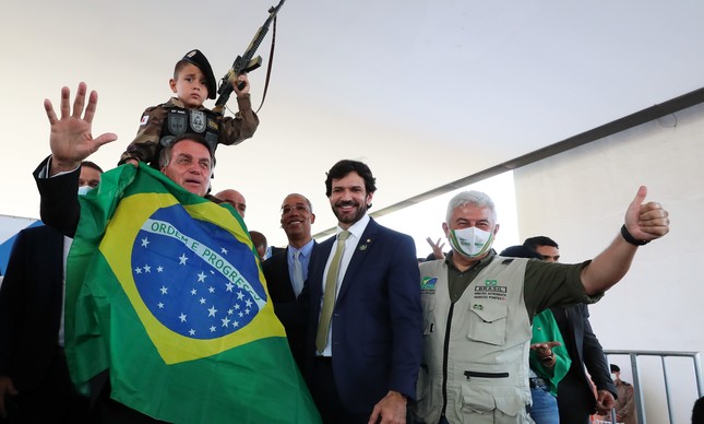 Bolsonaro segura criança ostentando fuzil