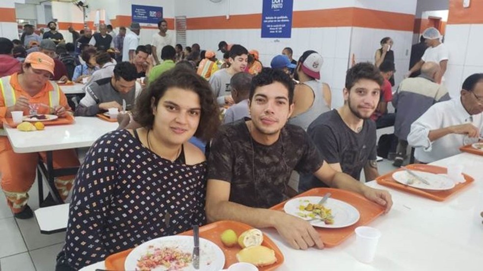 Isis, 22, ao lado do amigo Kevin, 28: sem renda, ela junta as moedas para almoçar todos os dias a R$ 1 — Foto: BBC Brasil