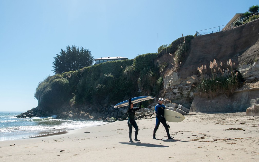 Surfistas deixam a Privates Beach de Santa Cruz, na Caifórnia, no dia 19 de setembro — Foto: Josh Edelson/AFP