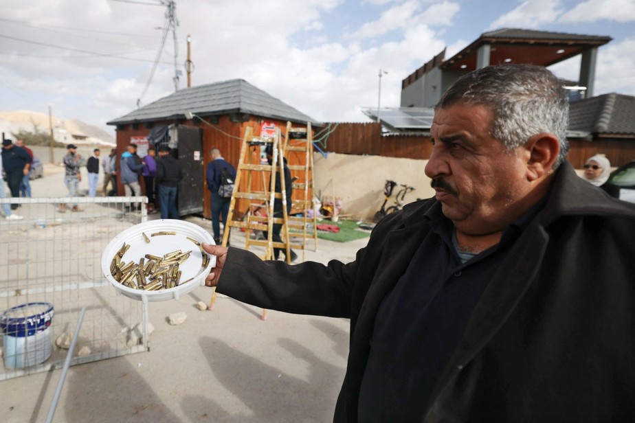Homem mostra cartuchos vazios após incursão israelense na Cisjordânia que matou cinco pessoas