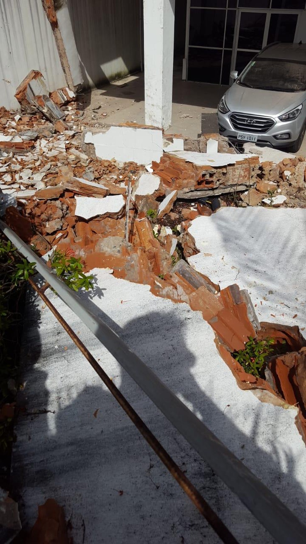 Por pouco, destroÃ§os nÃ£o atingiram um veÃ­culo que estava estacionado no pÃ¡tio da secretaria. â Foto: DivulgaÃ§Ã£o/Redes Sociais