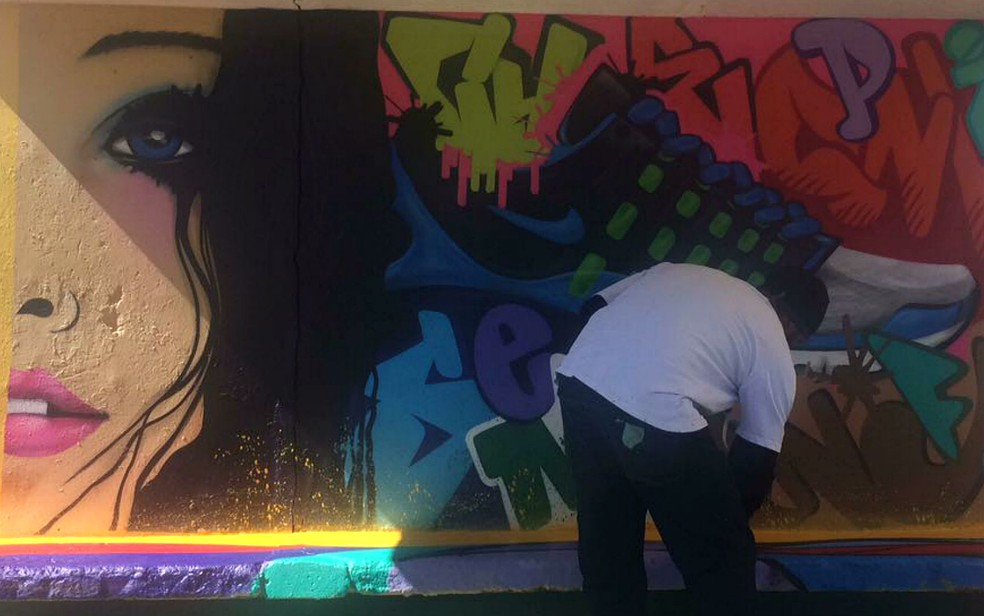 Grafiteiro Elon pinta parada de ônibus em Taguatinga, no Distrito Federal (Foto: Administração de Taguatinga/Divulgação)
