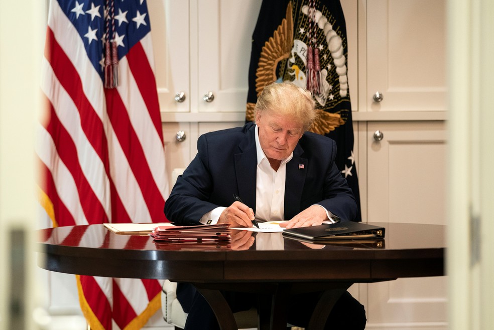 Donald Trump assina documentos em suíte de hospital, em foto divulgada pela Casa Branca no sábado (3) — Foto: Joyce N. Boghosia/Casa Branca/Reuters