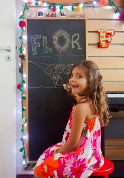 Flor, filha da apresentadora Bela Gil, se diverte na lousa que fica presa ao painel de madeira tauari ripado (Foto: Andrea Marques para NaToca/Divulgação)