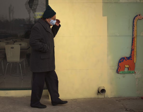 Homem usa máscara para ir à rua em Pequim por conta do alto nível de poluição. (Foto: Alexander F. Yuan/AP Photo)