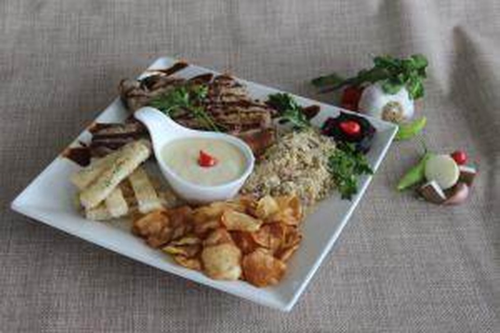 Bisteca suína ao crème de queijo minas acompanhada de chips de batata doce, farofa de bacon com banana e palitinho de pão — Foto: Comida Di Buteco/ Divulgação