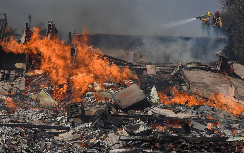 Bombeiros combatem chamas de incêndio em Ventura, na Califórnia, na terça-feira (5) (Foto: Mark Ralston/AFP)