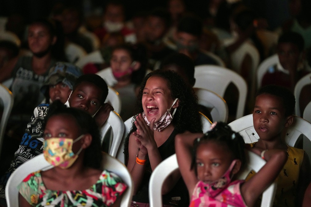 13 de setembro - Crianças assistem a filme no projeto cultural "Cinema no Morro", na favela Vila Cruzeiro, no Rio de Janeiro — Foto: Silvia Izquierdo/AP