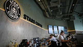 Funcionários servem clientes na principal loja da nova rede Stars Coffee, no centro de Moscou — Foto: NATALIA KOLESNIKOVA / AFP