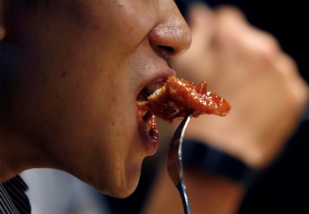 Homem come frango frito em um bar de Seul, na Coreia do Sul (Foto: Kim Hong-Ji/Reuters)