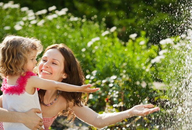 Mãe e filha brincando com água na natureza (Foto: Shutterstock)