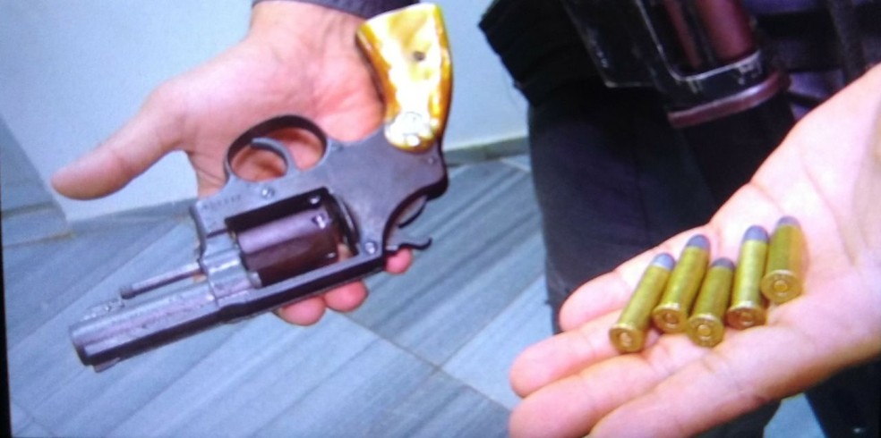 Policial mostra arma encontrada com o soldado da FAB preso apÃ³s assalto em Natal (Foto: Rafael Barbosa/G1)