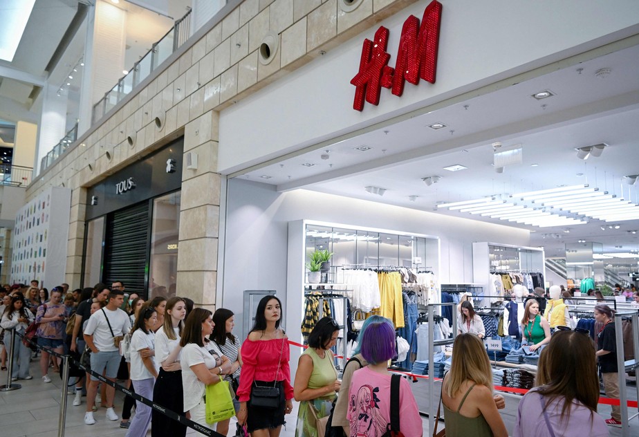 Pessoas fazem fila do lado de fora de uma loja de roupas H&M, que abriu as vendas finais antes de encerrar suas operações comerciais na Rússia, no shopping Metropolis, em Moscou, em 3 de agosto de 2022