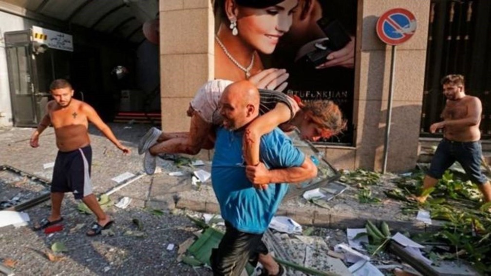 Homem retira mulher ferida de escombros em Beirute — Foto: Getty Images/Via BBC