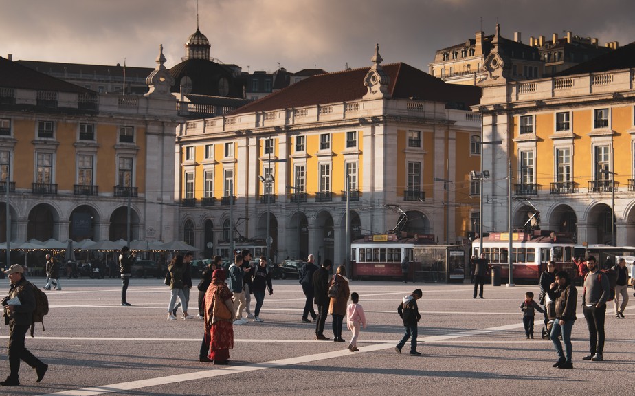 Pedestres caminham no Terreiro do Paço, em Lisboa