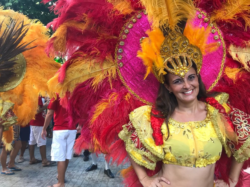 Vestida com cores exuberantes e graciosas plumas, a promotora de eventos Marcela Fernandes conta que espera o ano todo para dançar o frevo (Foto: Thays Estarque/G1)