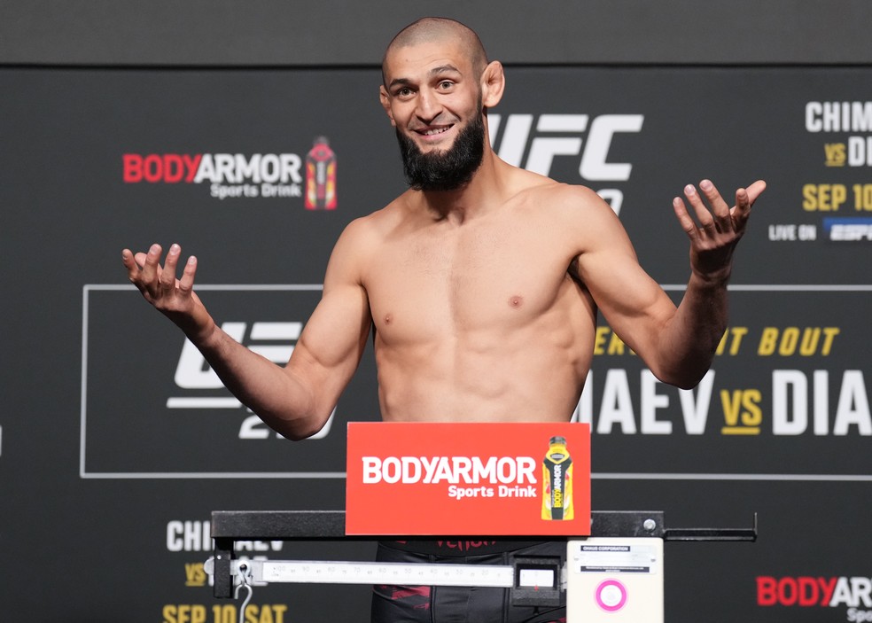 Khamzat Chimaev, mesmo falhando no corte de peso no meio-médio, sorriu diante das câmeras ao subir na balança — Foto: Chris Unger/Zuffa LLC